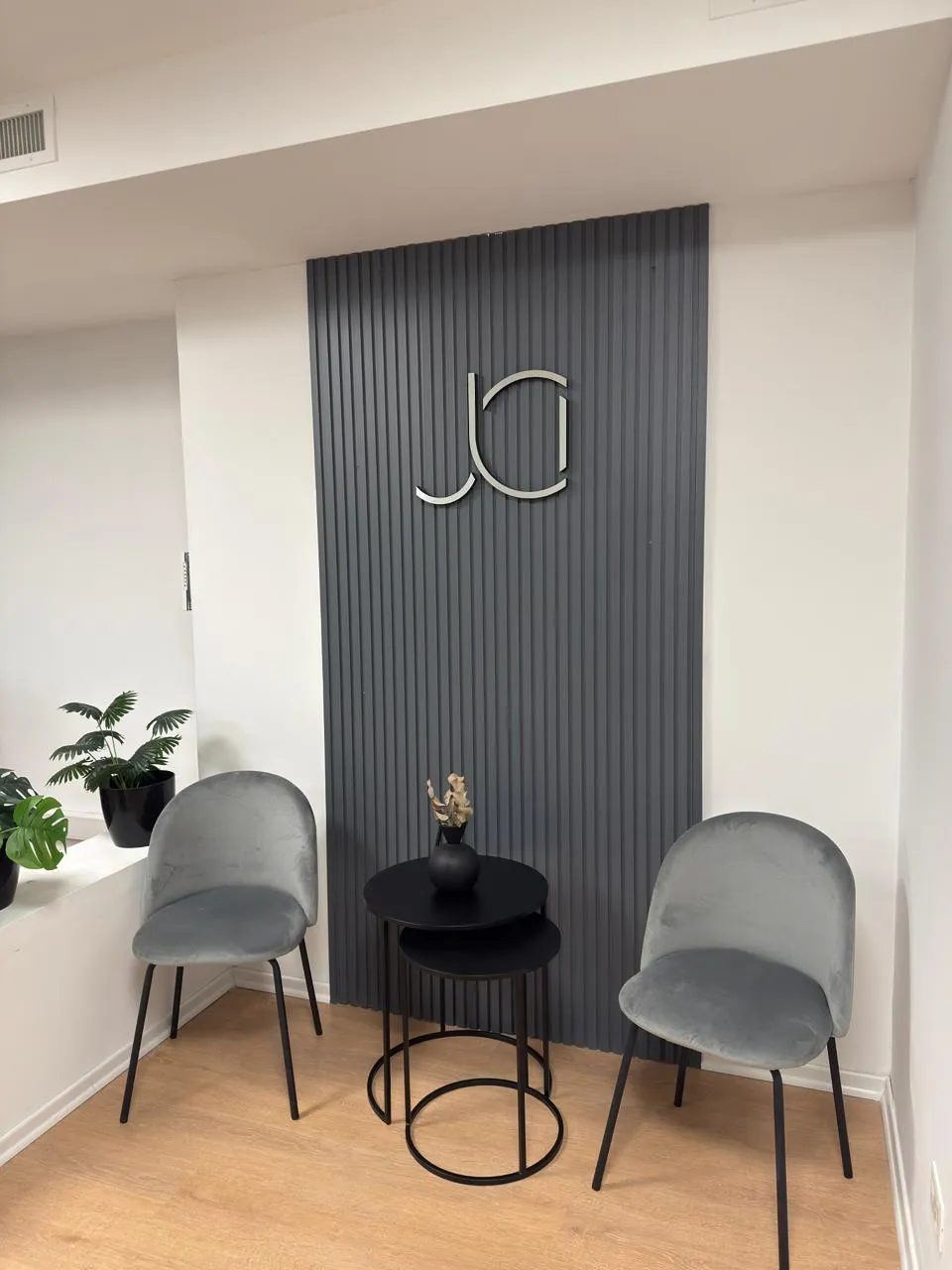Vista frontal de la zona de espera del estudio, destacando el diseño minimalista y la iluminación cálida.